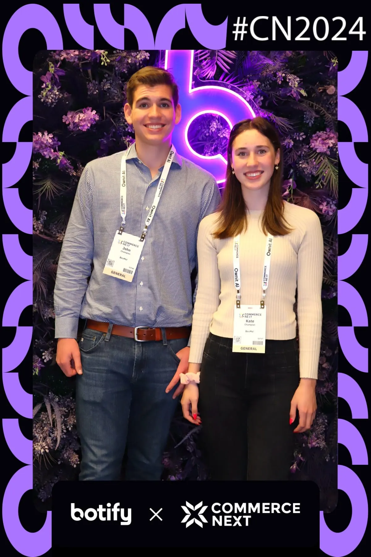 Two conference attendees posing at the CommerceNext neon flower wall