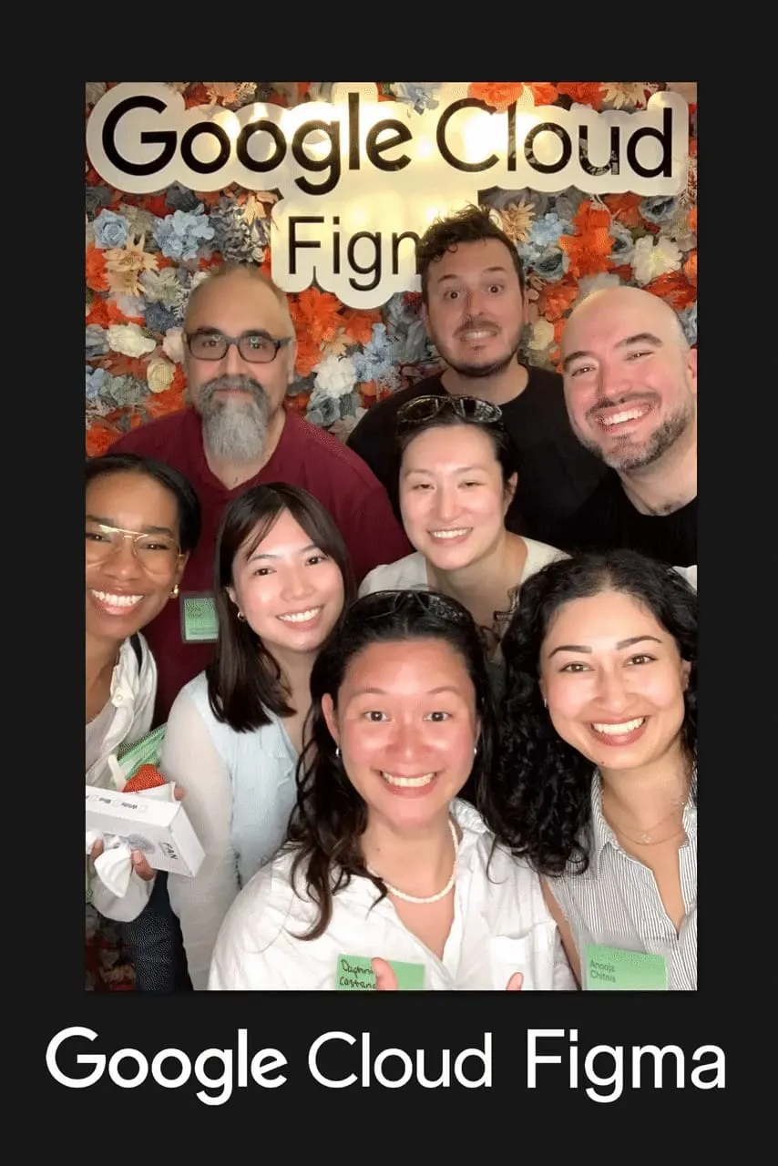 Eight guests crowd into the frame at the Google Cloud × Figma event — flower wall