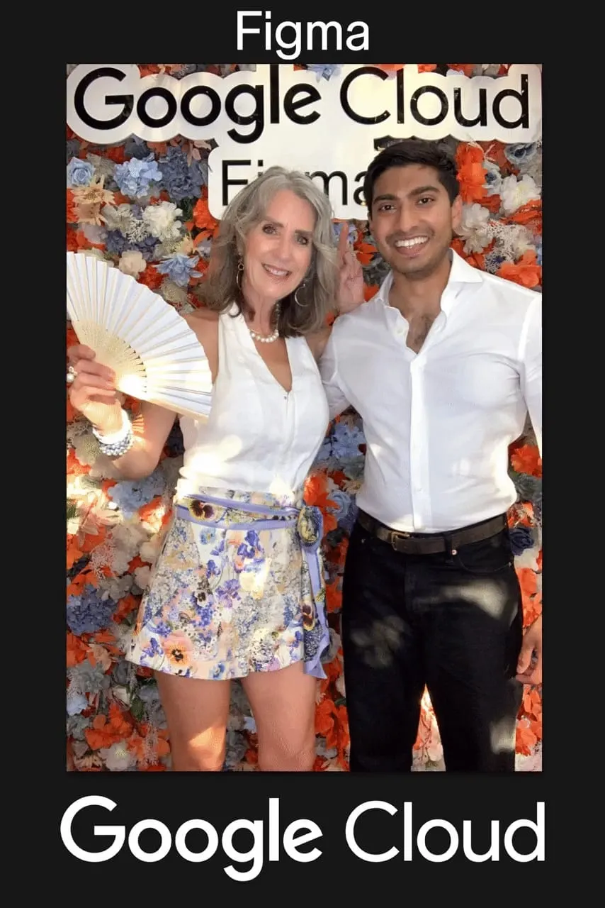 Two guests posing under the Google Cloud Figma sign at the branded flower wall