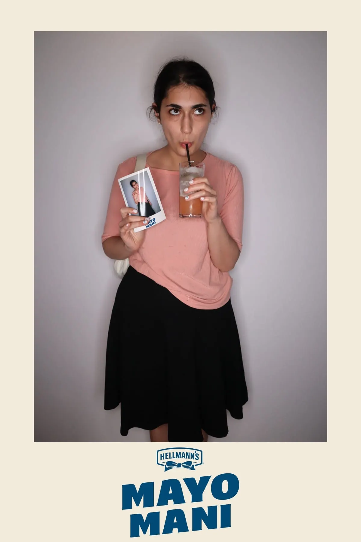 Guest sipping a cocktail and holding her Mayo Mani instant print