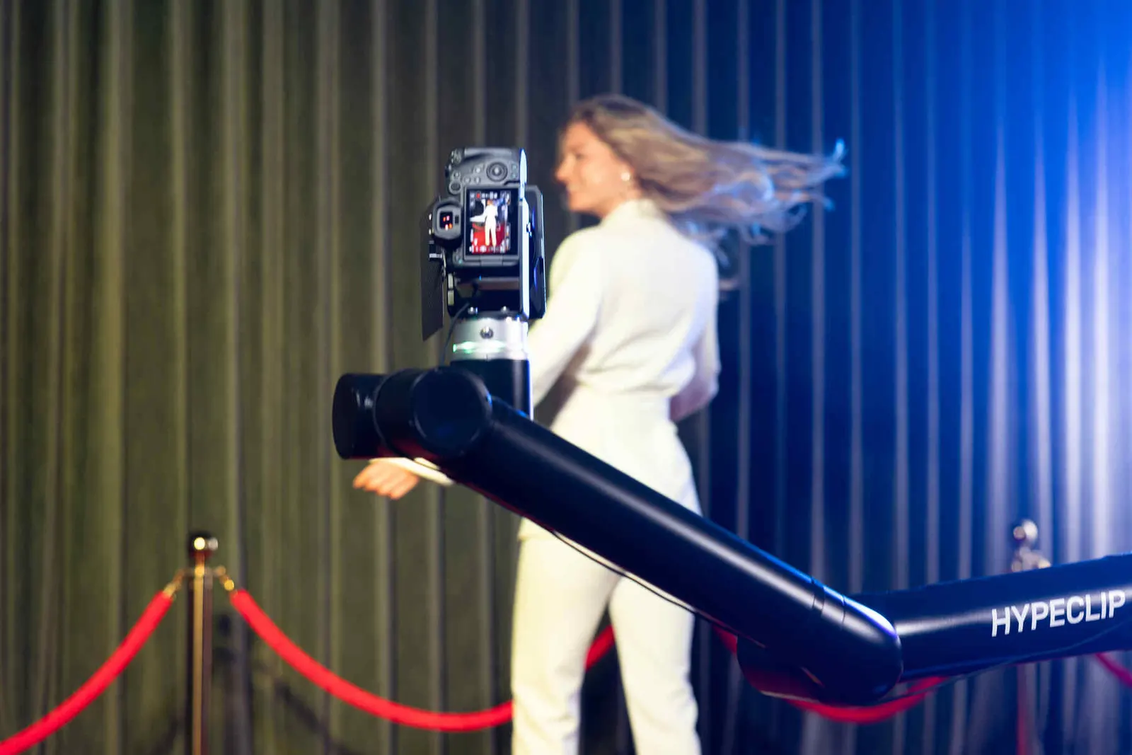 Robotic camera arm mid-sweep at an evening event
